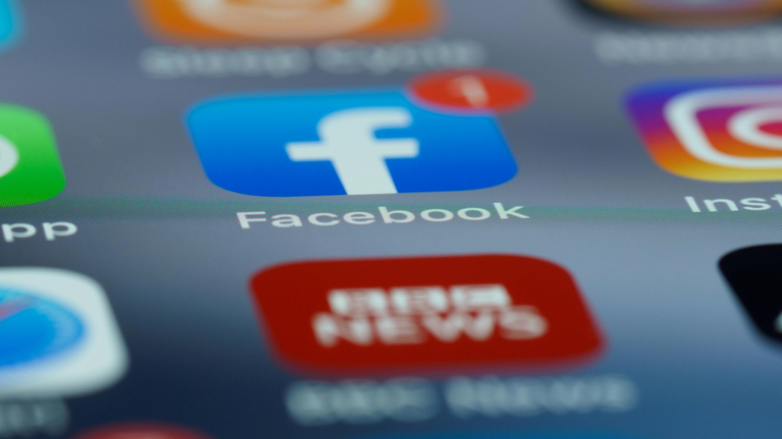 Close-up of smartphone screen displaying various social media app icons including Facebook.